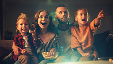 Красивая семья с двумя детьми смотрит фильм